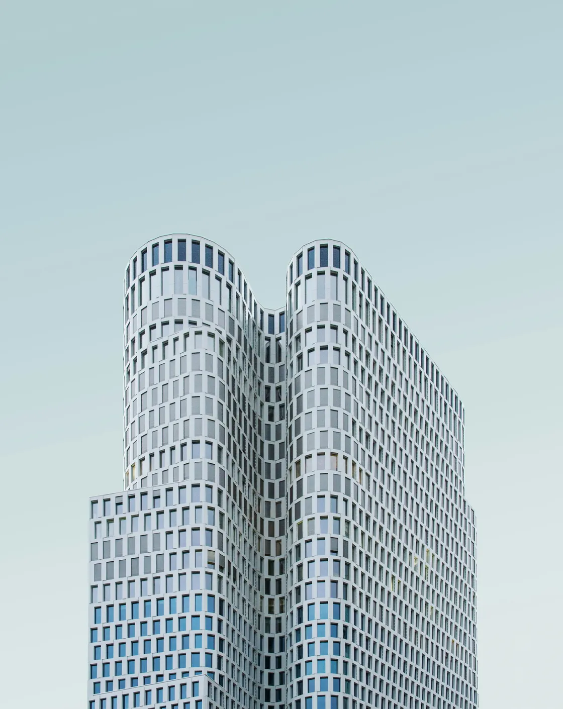 Curving white facade against a clear sky, photographed in Berlin