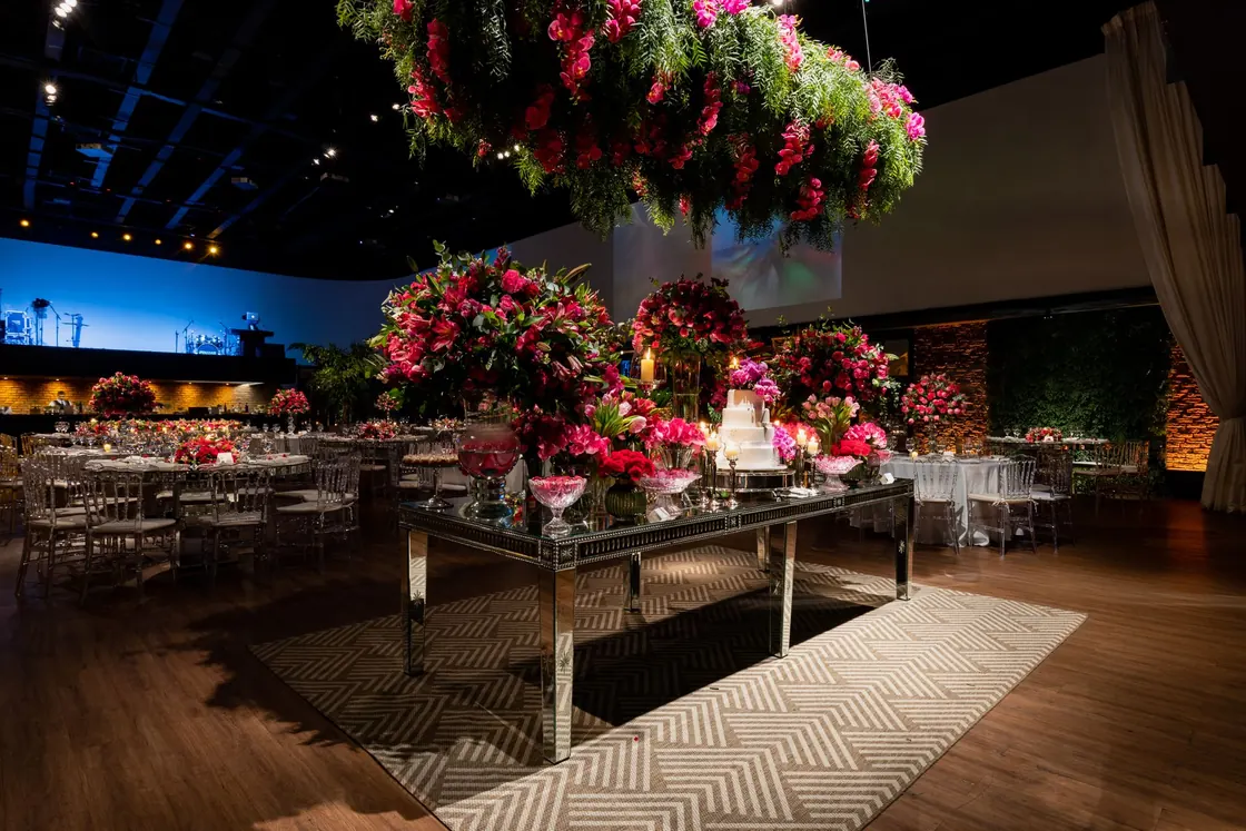 A formal reception table surrounded by flowers and hanging decorations