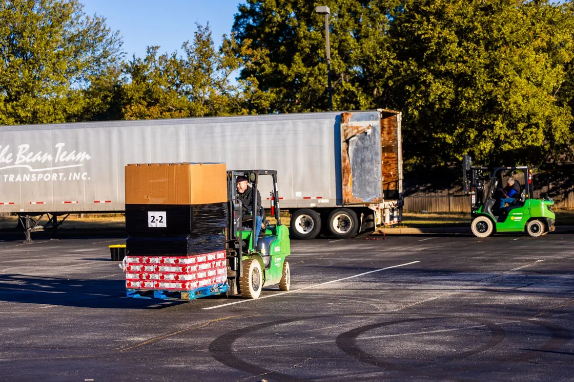 Forklift operators loading pallets onto a goods vehicle