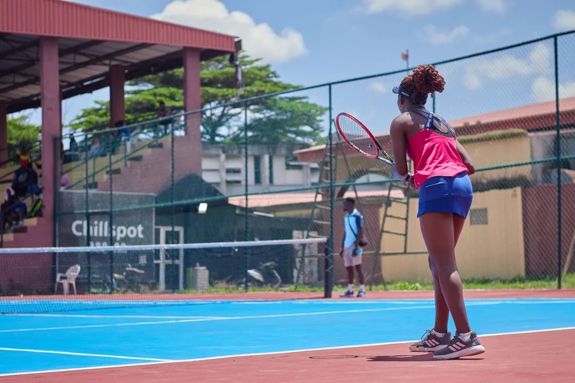 A woman playing tennis on an outdoor court
