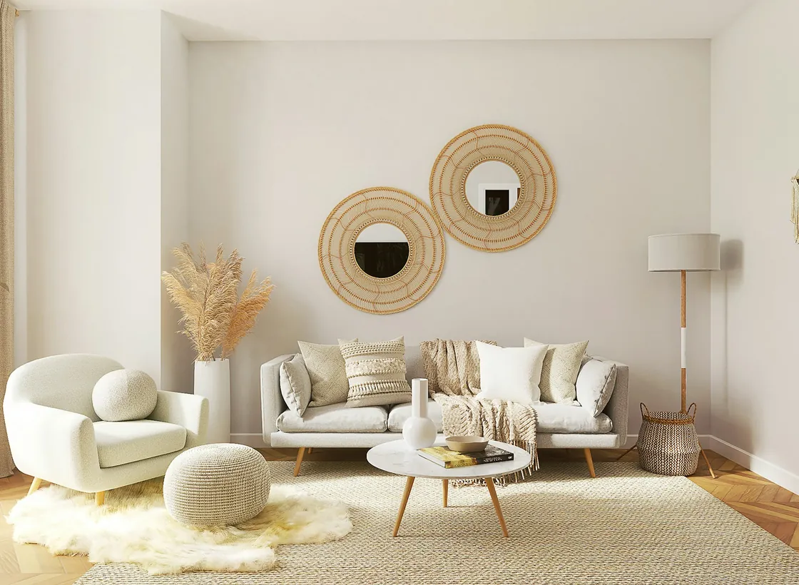 Light living room with two round woven mirrors, a sofa and a pale upholstered chair