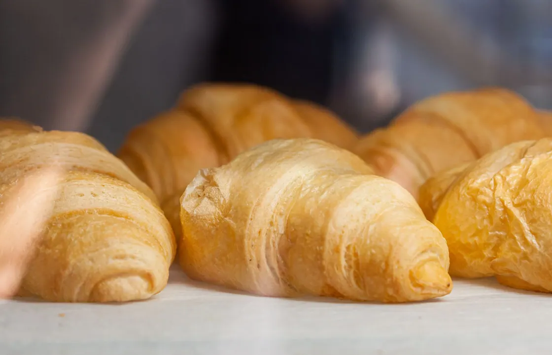 Golden croissants arranged across a bakery counter