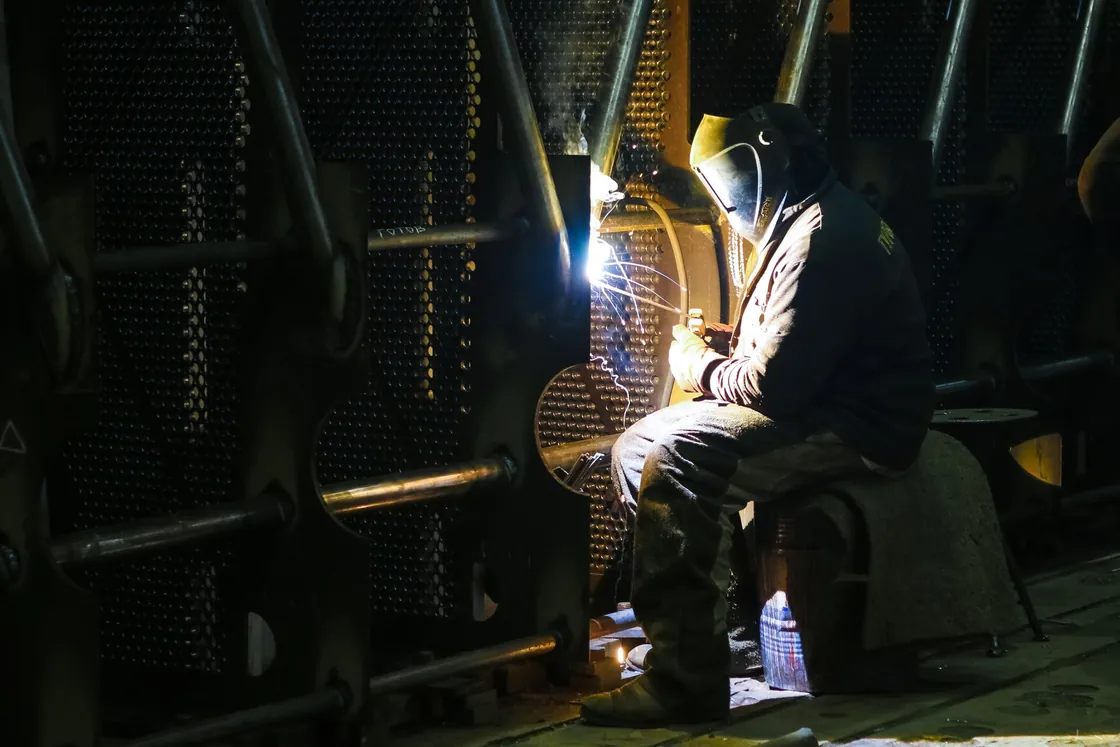 Welder at work with protective helmet and gloves