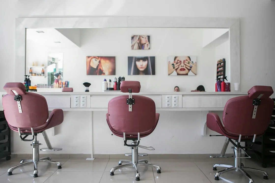 A bright hair salon with styling chairs, mirrors and warm interior details