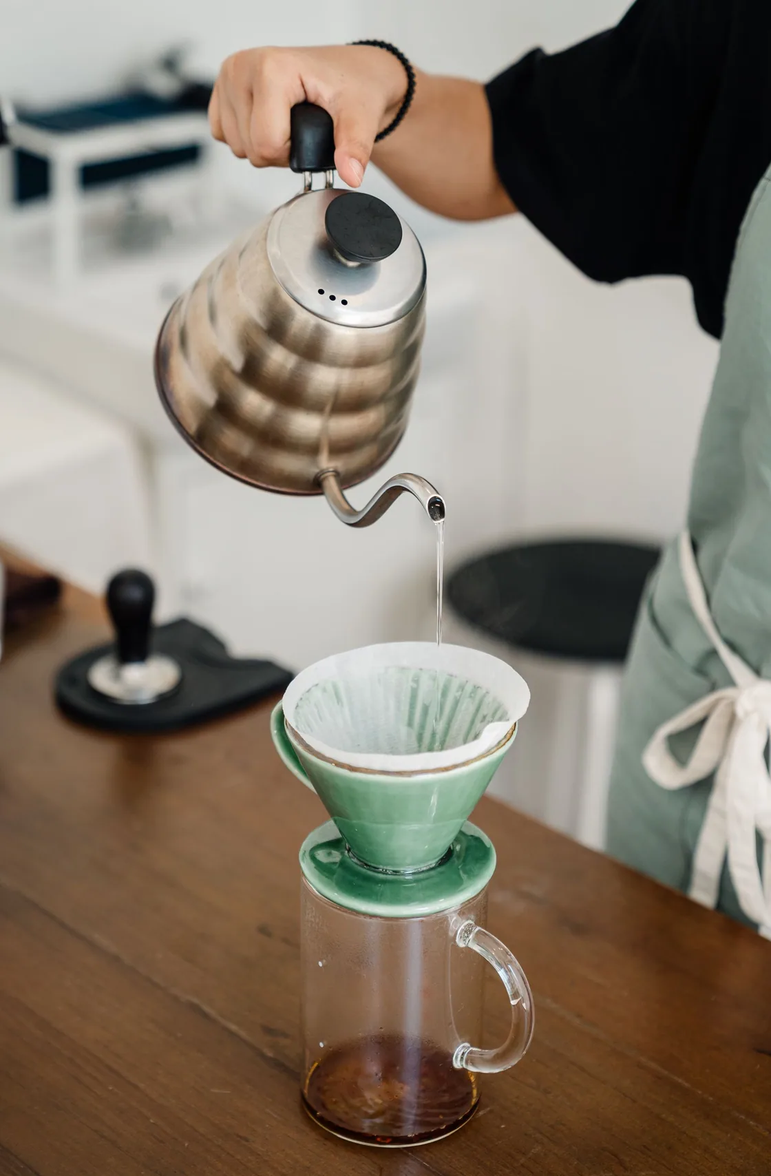 Water poured onto coffee grounds in a paper-filter dripper