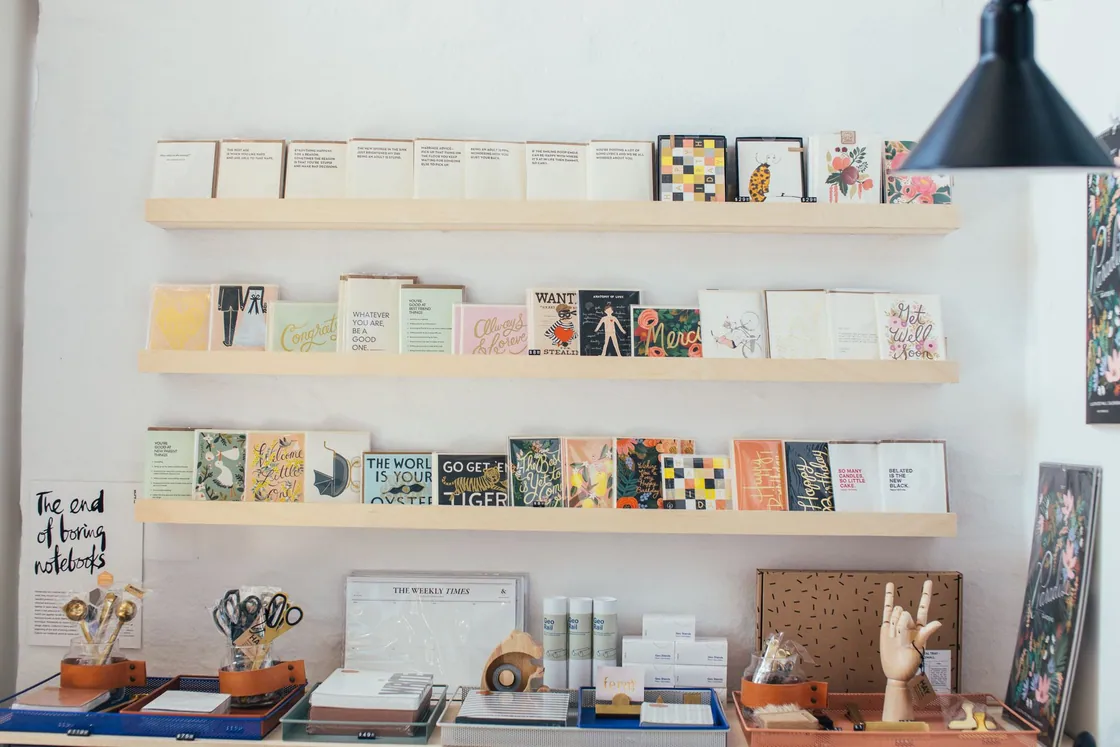 Books and stationery arranged on wooden shelves in a bookshop
