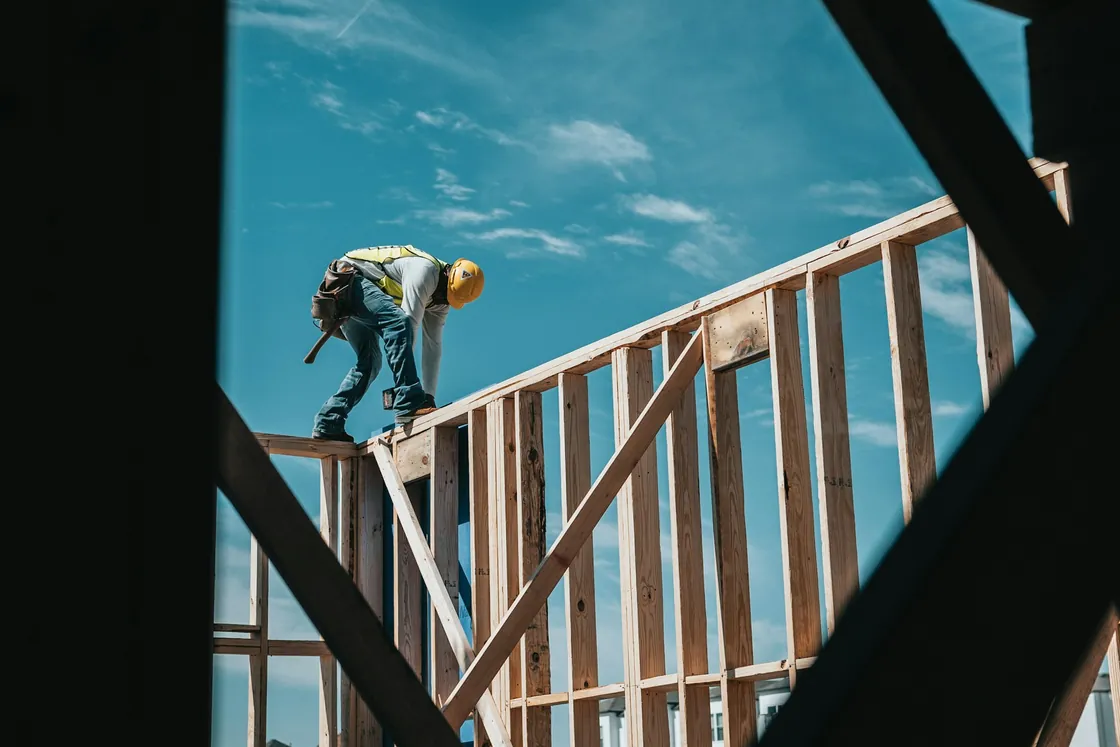 Construction worker standing on a timber building frame