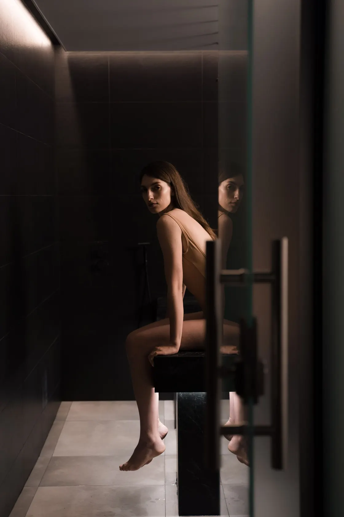 A woman sitting beside timber benches in a sauna