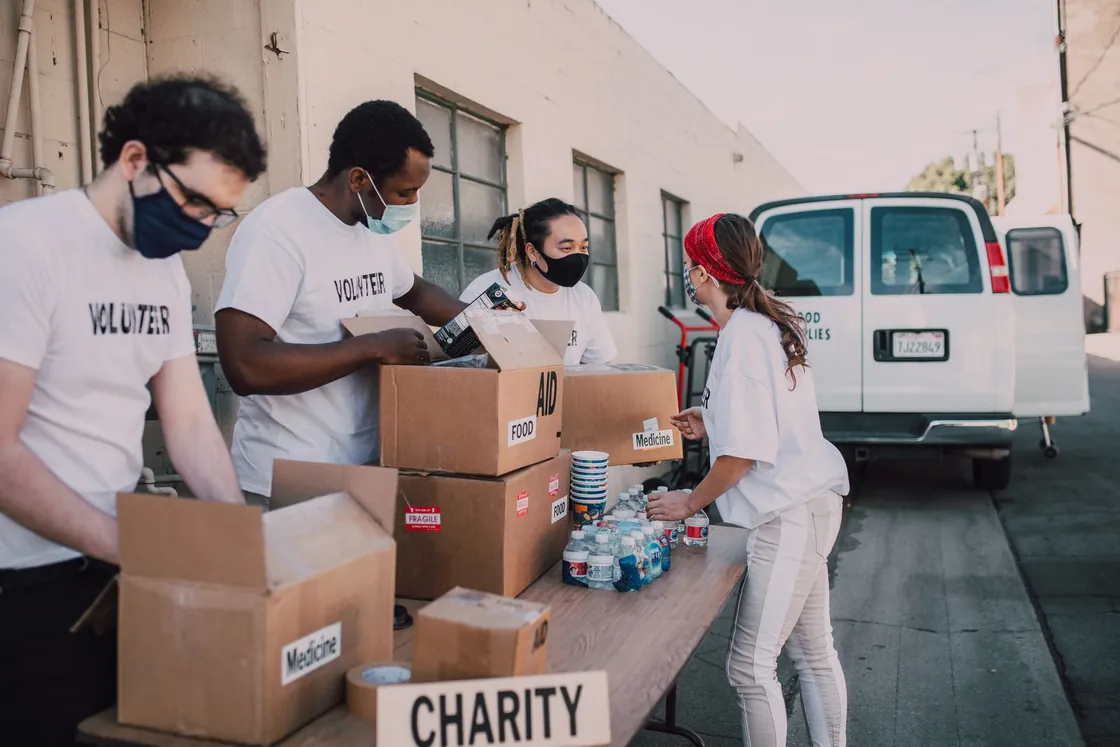 Volunteers sorting goods from boxes outdoors