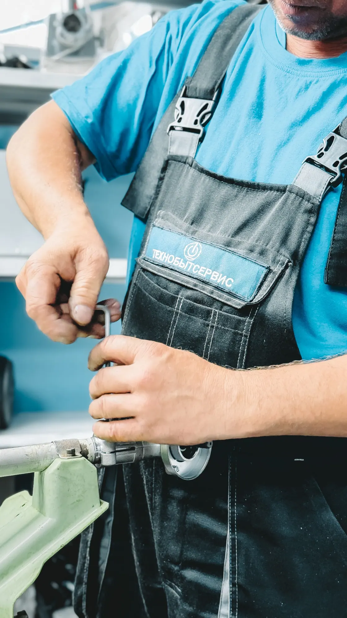 A plumber in a blue uniform working on pipework