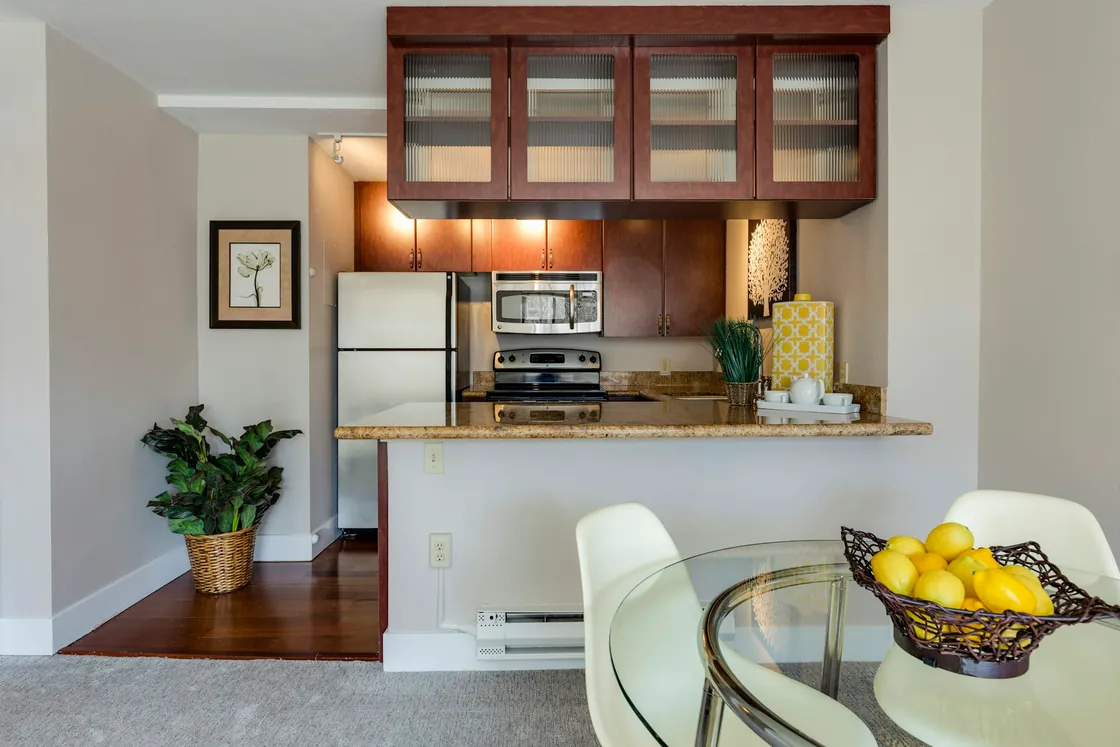 A light open-plan interior with a dining table and kitchen beyond