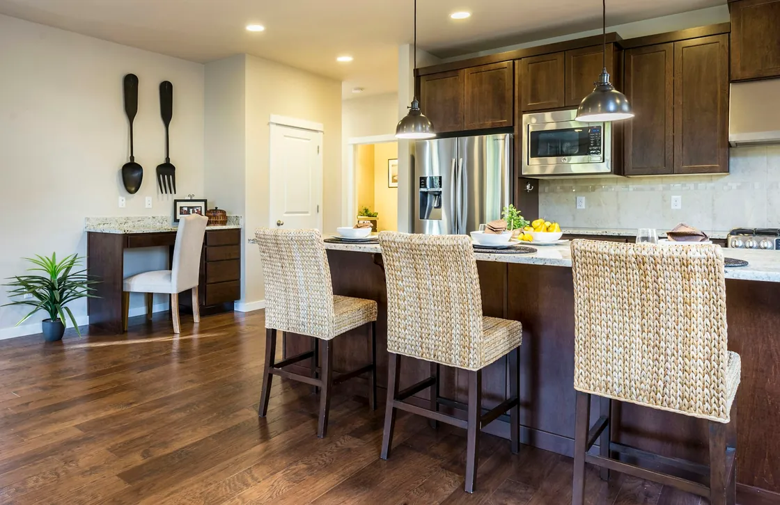 A light kitchen with woven chairs and a white island