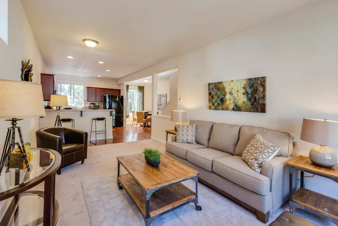 A sitting area with a sofa, coffee table and open kitchen in the background