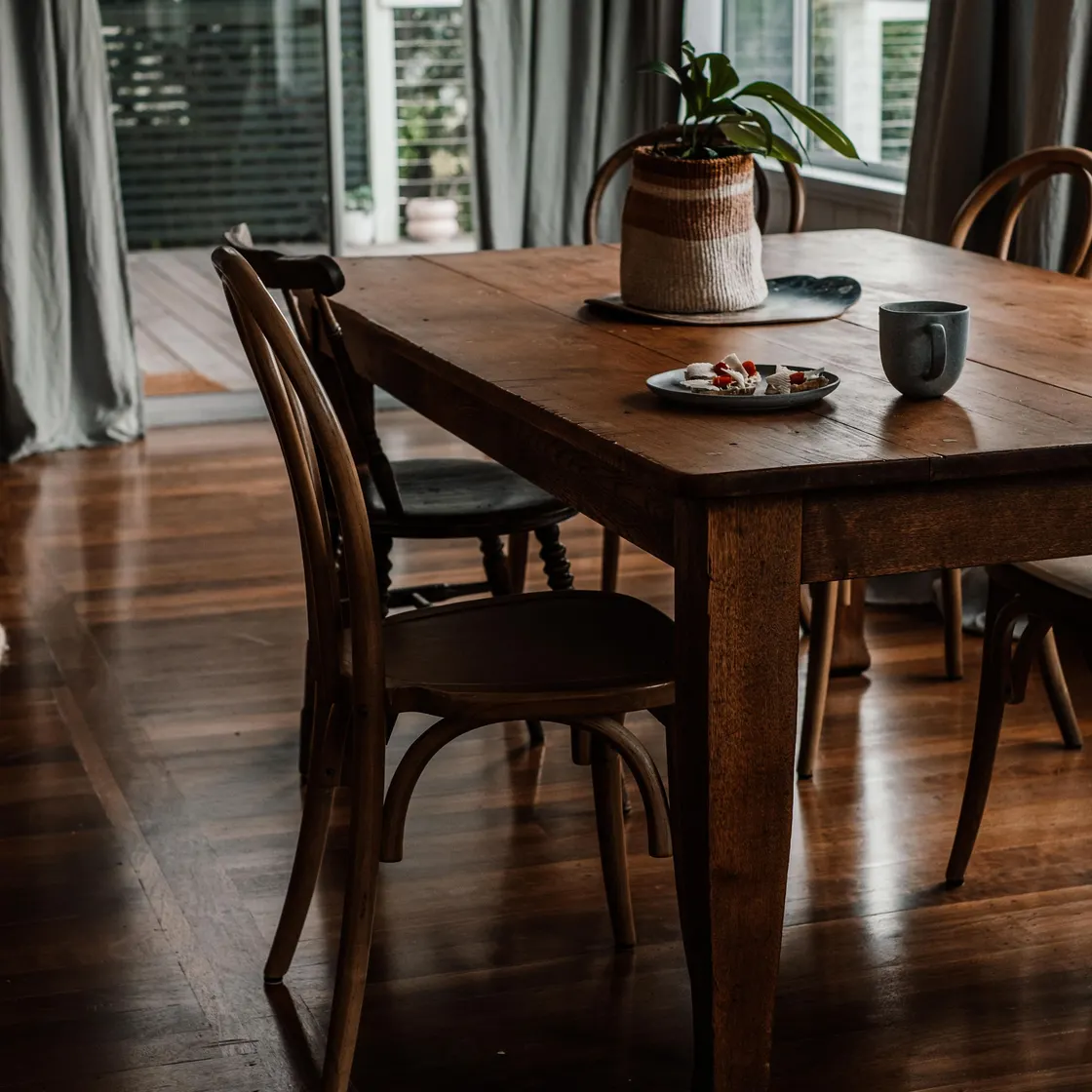 Close view of warm wooden dining furniture beside a window