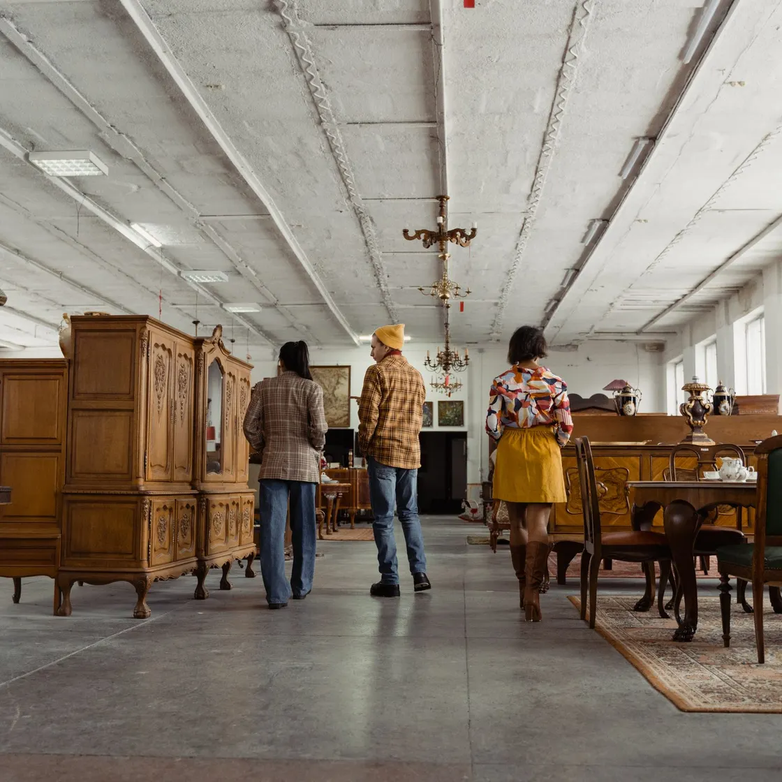 People looking around a large vintage furniture showroom