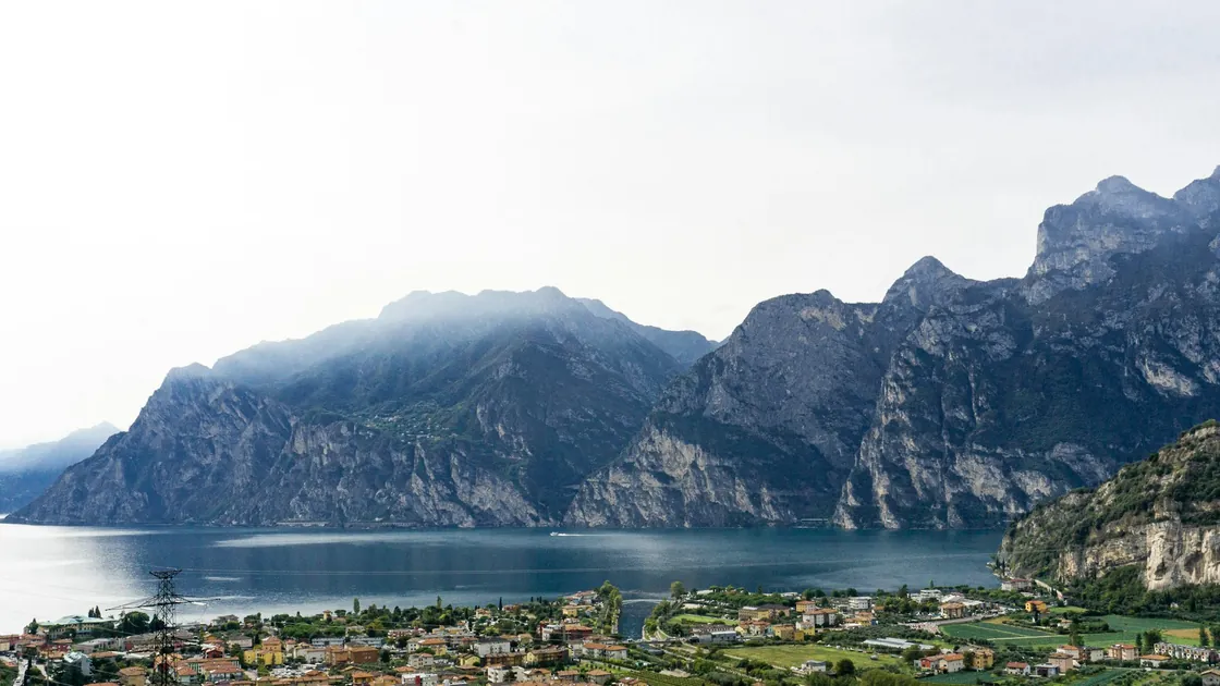 A waterfront town beside Lake Garda with mountains behind
