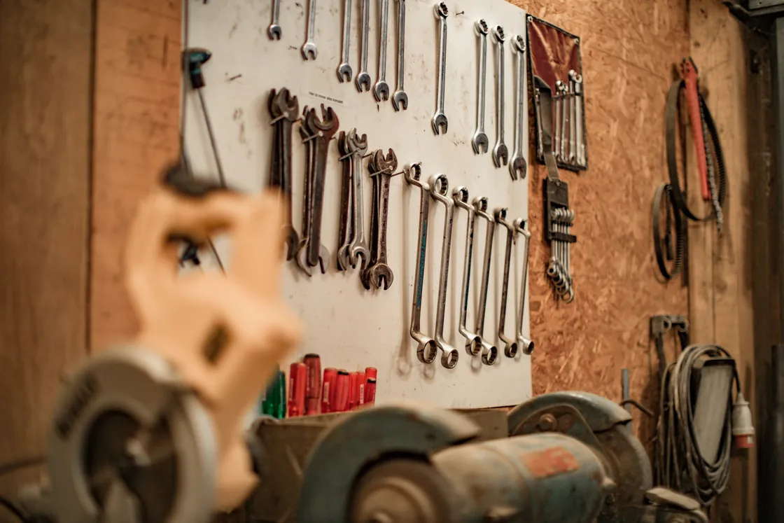 A workshop wall holding hand tools and equipment