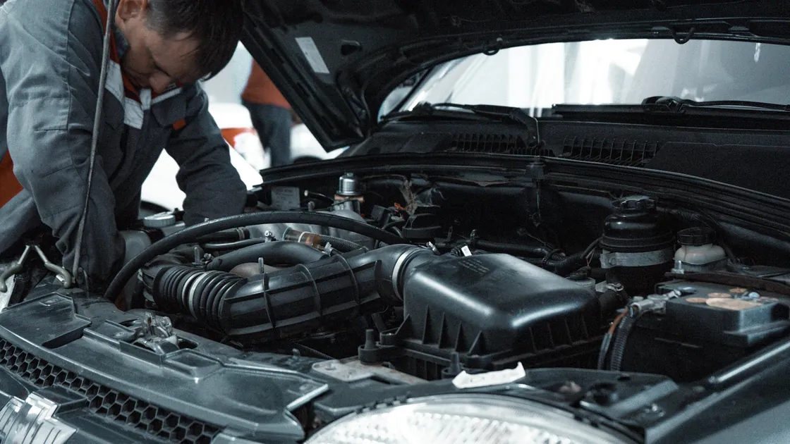 A mechanic inspecting an open car engine